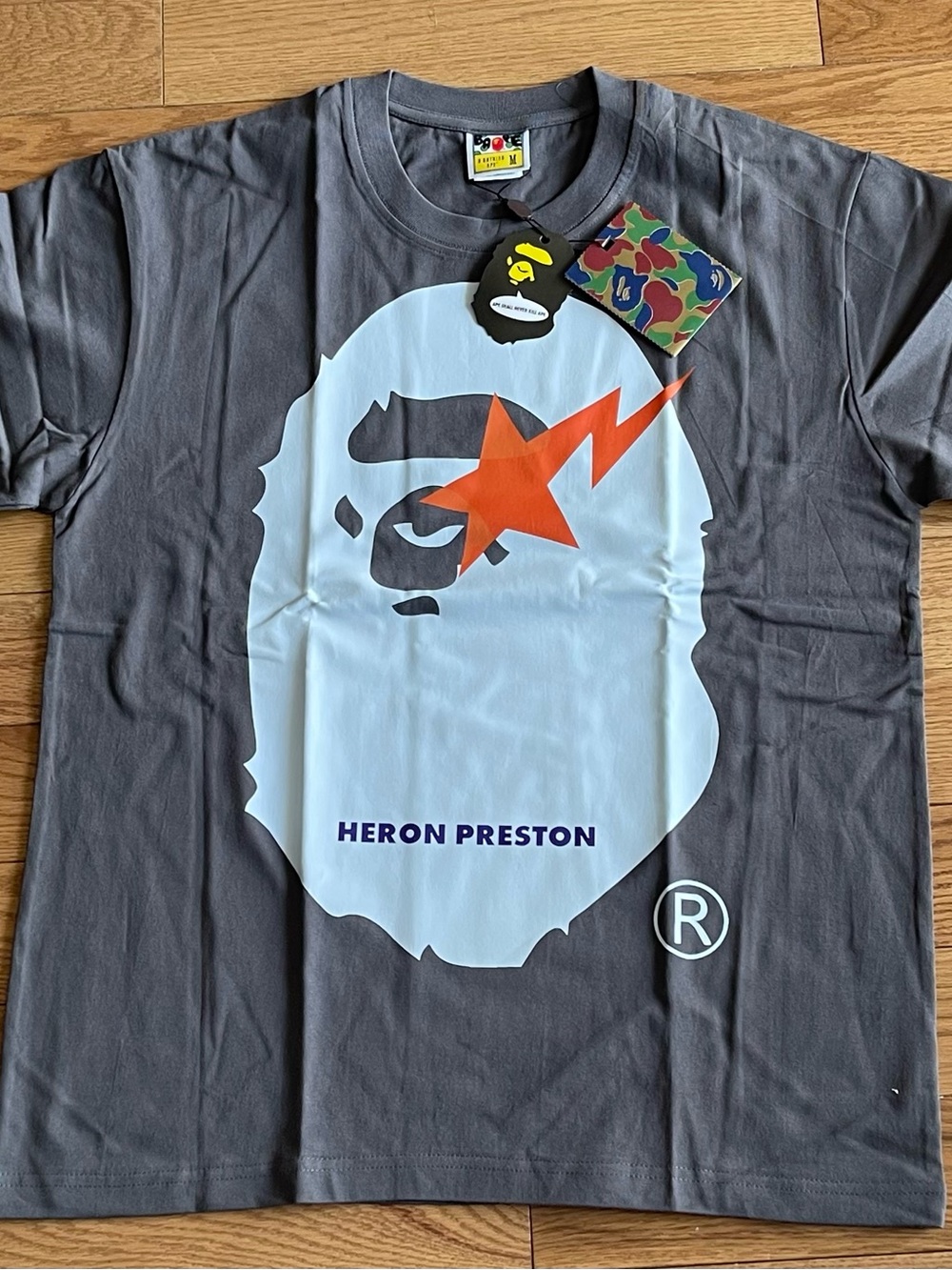 Heron Preston Charcoal Tee with White Face and Orange Star